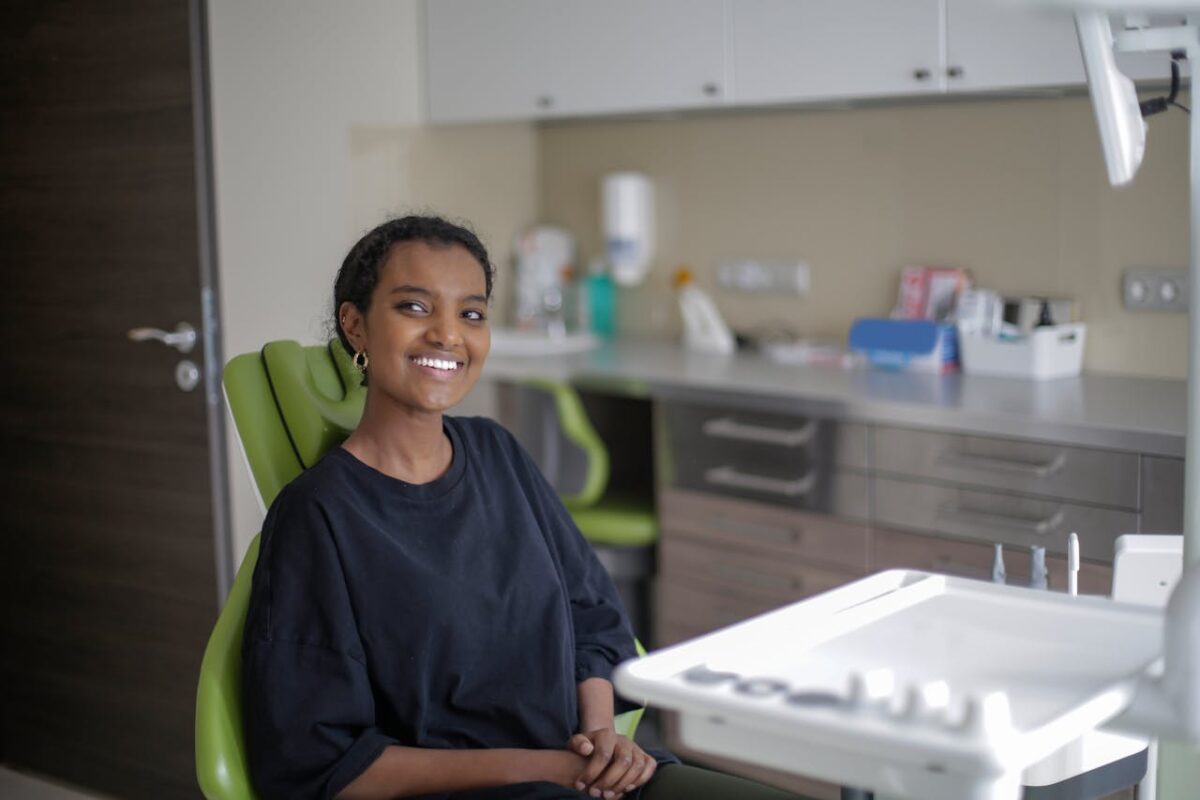 Cheerful woman sitting on dental chair in a dental office