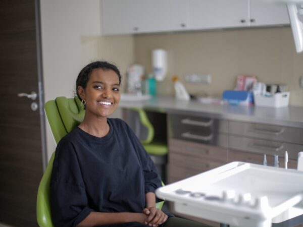Cheerful woman sitting on dental chair in a dental office